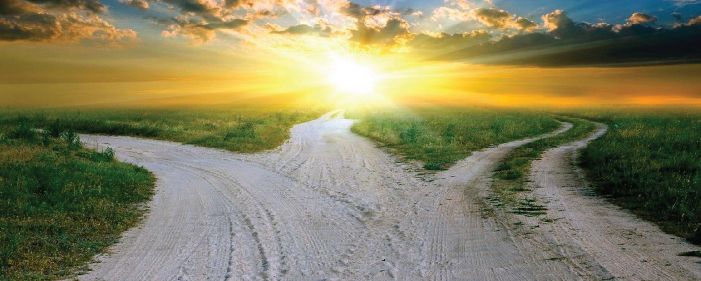 Dirt road leading to three different paths sunrise in background