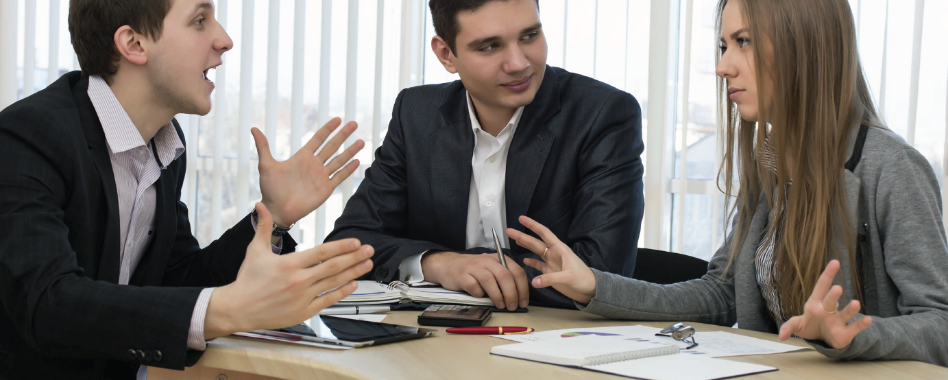 Young people around desk having a conversation