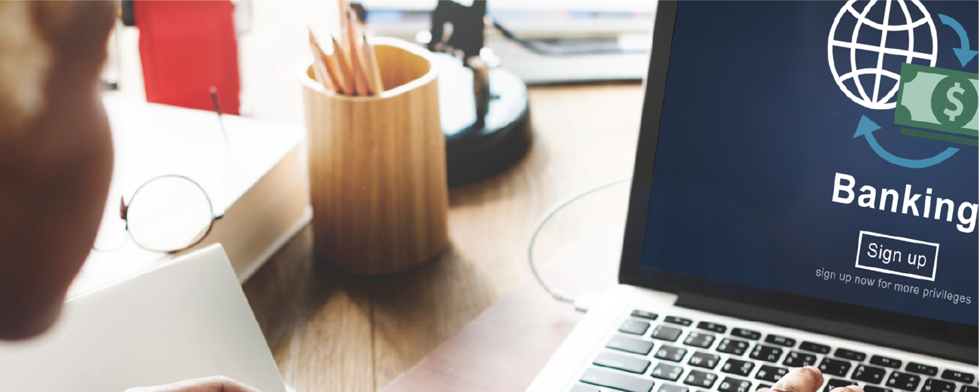 person not visible sits at desk pressing laptop keys