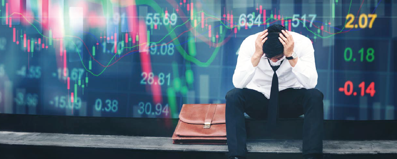 Man with hands on his head briefcase next to him back ground showing stock numbers
