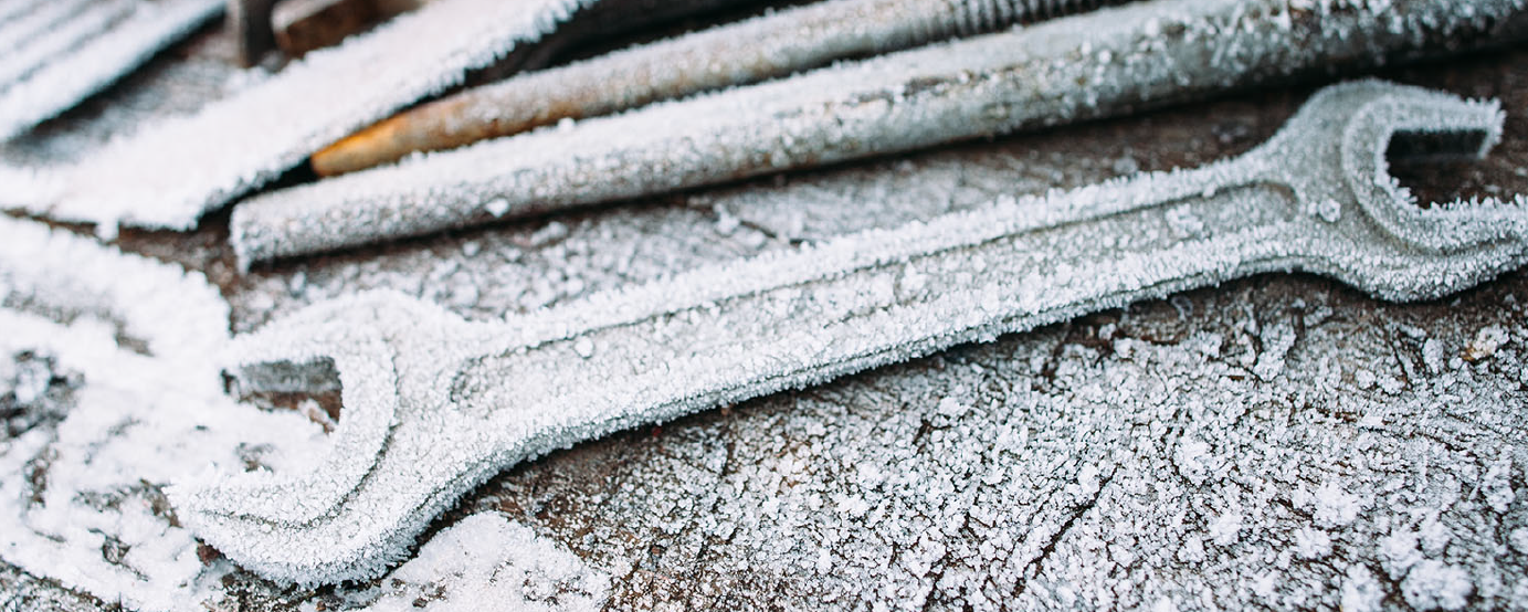 wrench and various other tools covered with snow