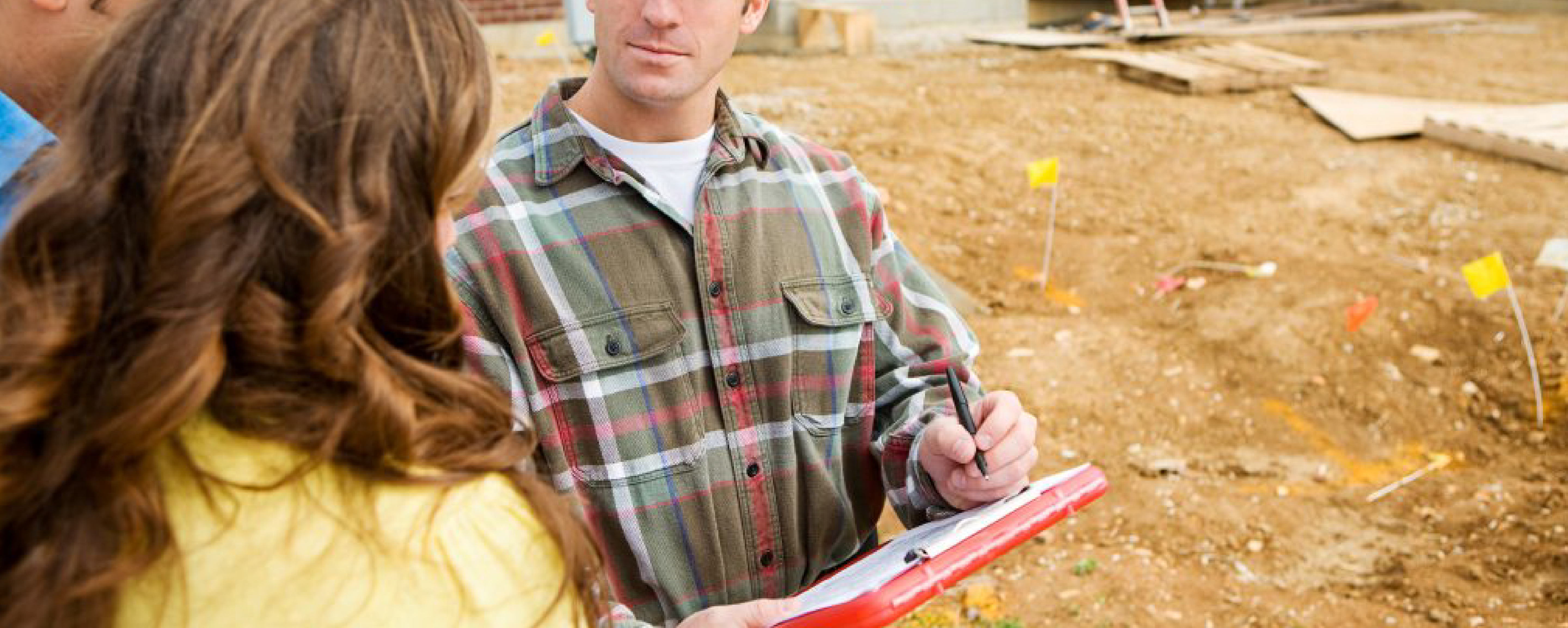 contractor with pen and paper in hand talks with customer about exterior remodel