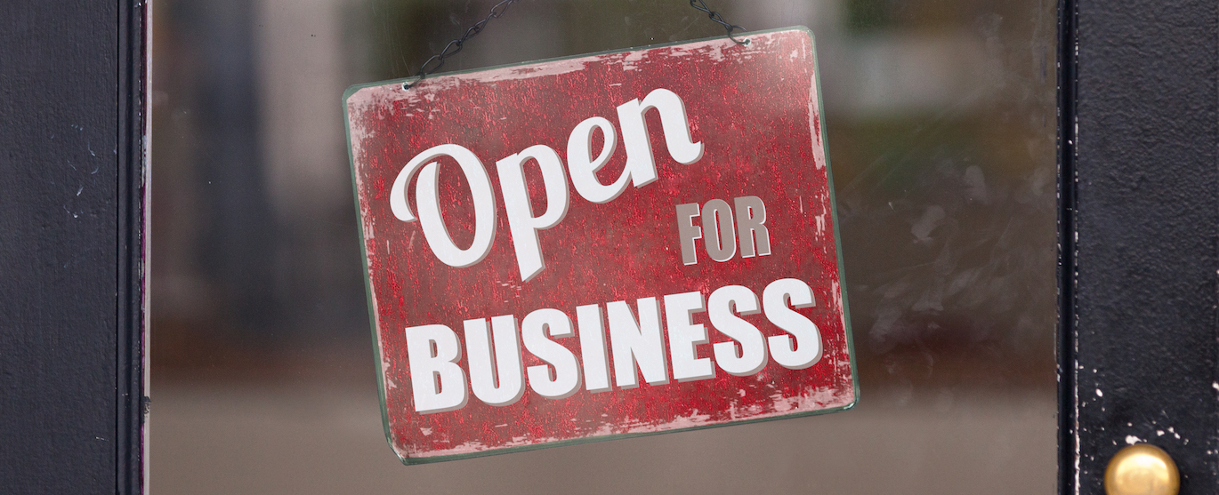 OPEN for Business Sign hangs on glass door