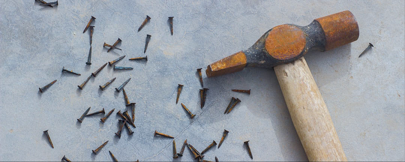 Rusty wooden hammer and tacks