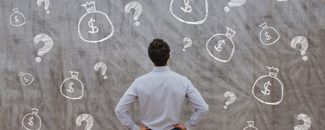Man looking at board with question marks and bags with dollar signs on them contemplating