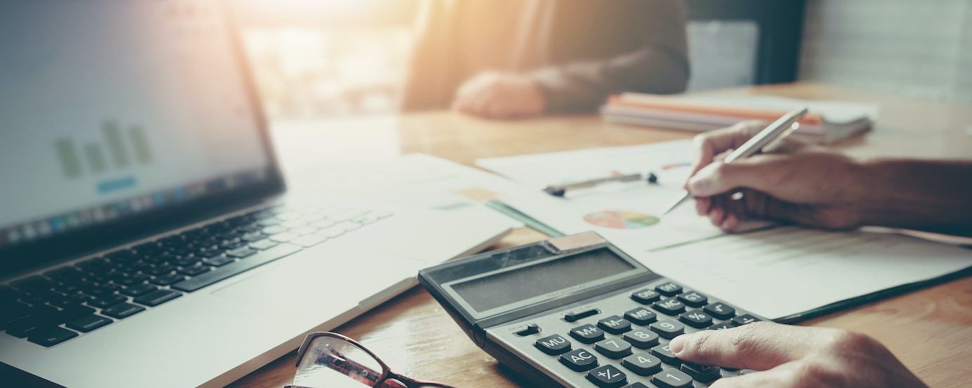 Close up Businessman and partner using calculator and laptop for calculating finance, tax, accounting, statistics and analytic research concept