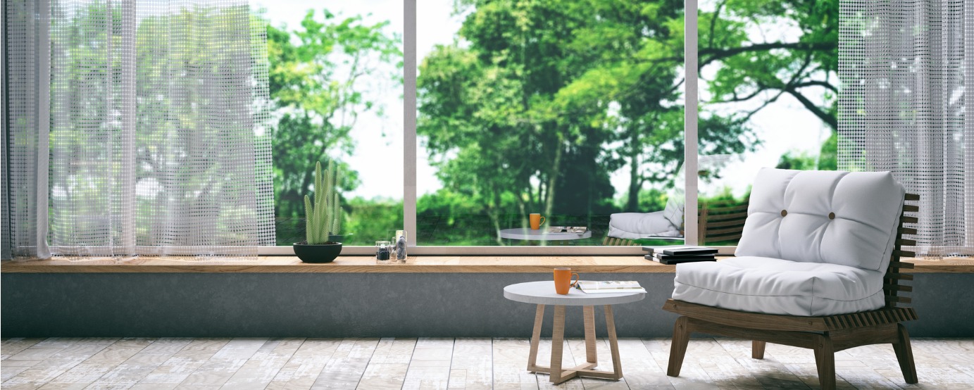 Sunroom with chair and small table in front of a window blurred trees out window