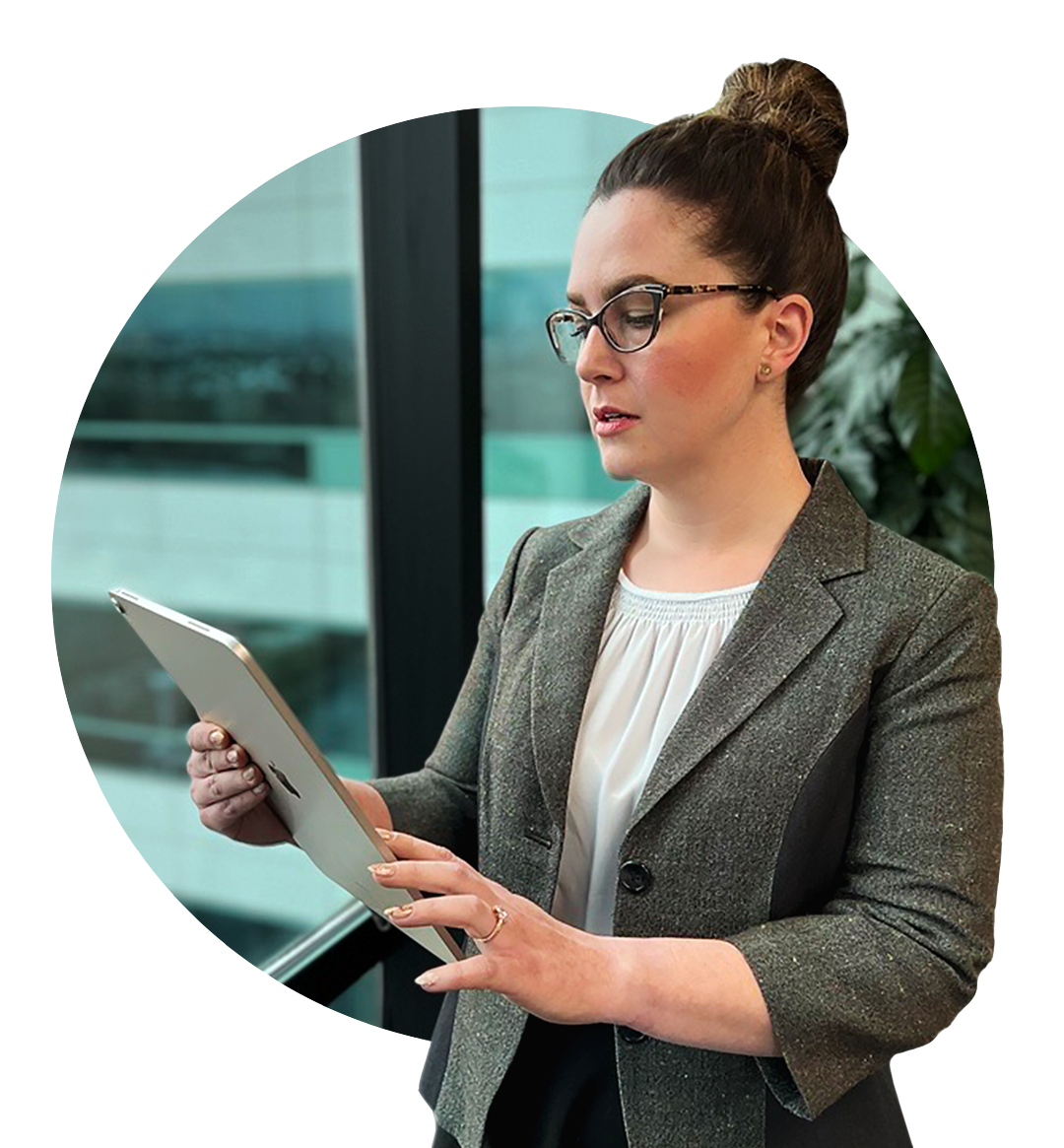 A female Bank employee stands looking at her iPad.